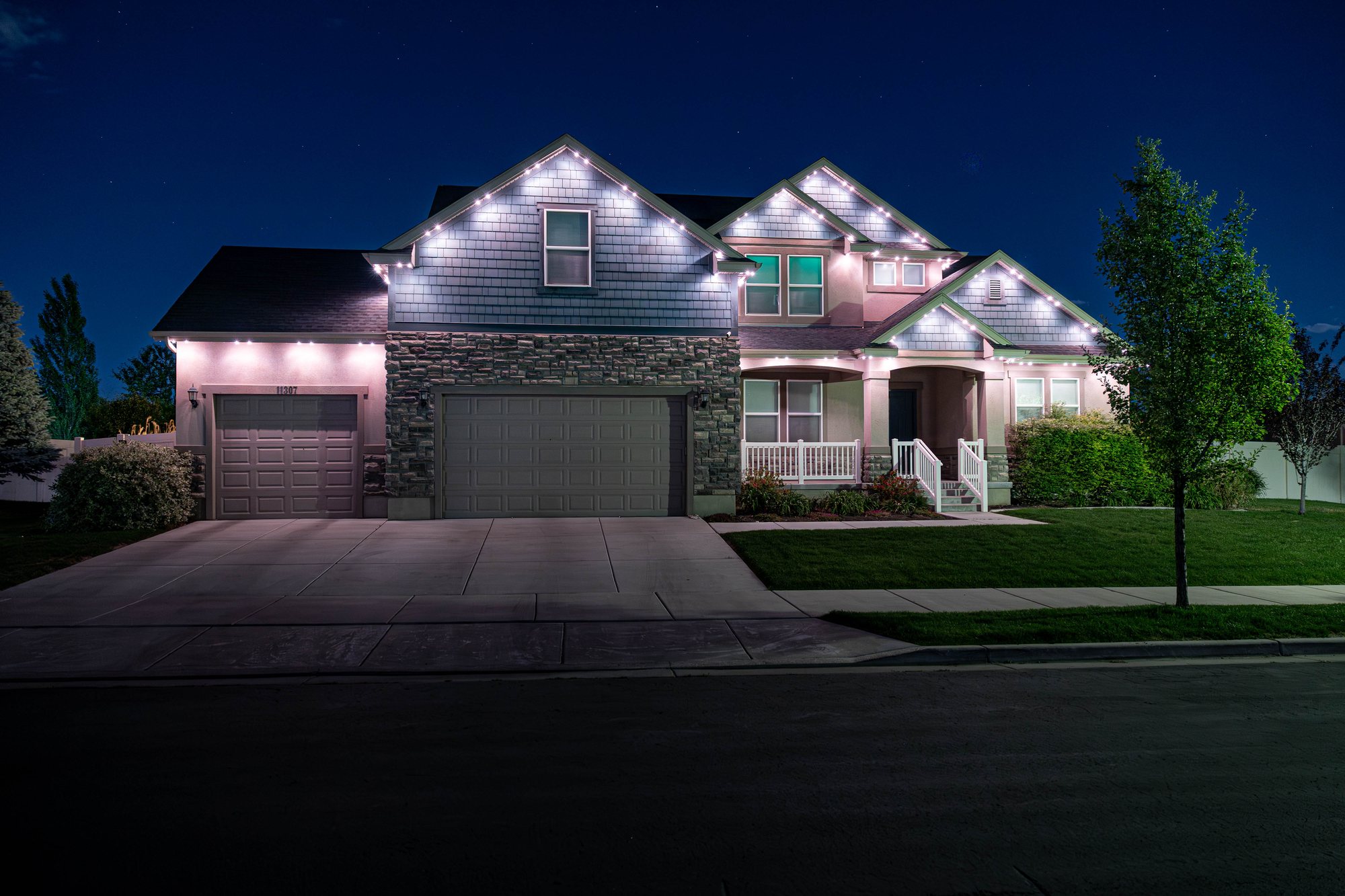 Same home by night — roofline illuminated