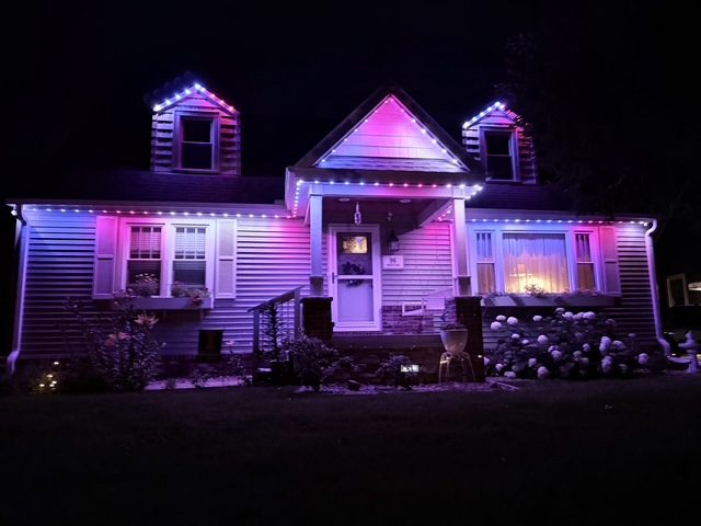 Cape-cod home lit in custom purple and blue