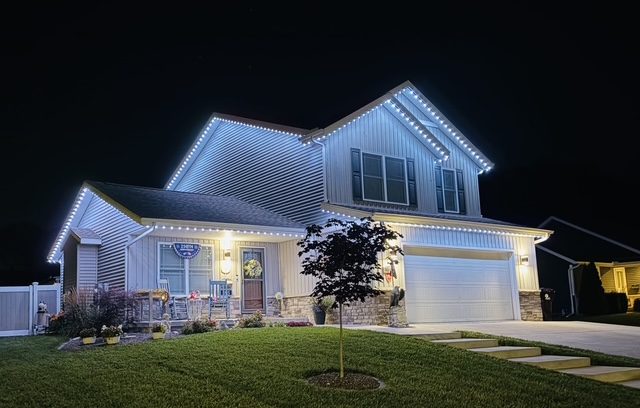Two-story Peoria home with warm-white permanent roofline lighting at night